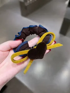 Dettaglio di fiocco in velluto e cuore su elastico marrone con cucitura blu