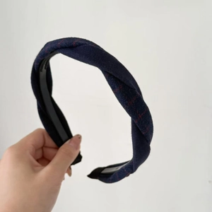 Detailed close-up of a vintage navy blue checkered twist knot headband with inner teeth