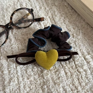 Dettaglio dell'elastico in velluto a cuore con bordo in denim su lana color crema