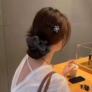 Chouchou à pois et pince à fleurs argentée de style coréen portés par un mannequin