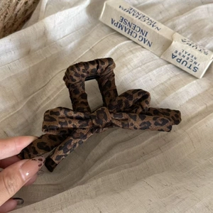 Elegant leopard print bow hair claw clip for women featuring classic French style fabric