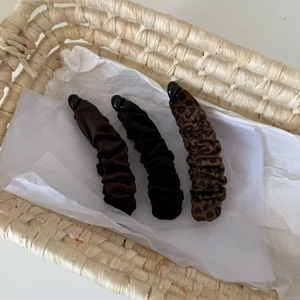 Detailed set of leopard print and velvet banana hair clips in a woven gift basket