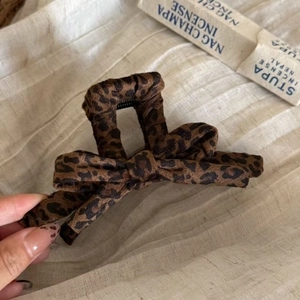 Handheld leopard print bow hair claw clip made of soft flocking material for elegant styling