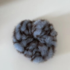 Close-up detail of plush faux fur scrunchie with grey-blue and brown leopard patterns