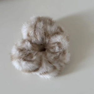 Detailed close-up of fluffy faux mink fur scrunchie with leopard pattern texture