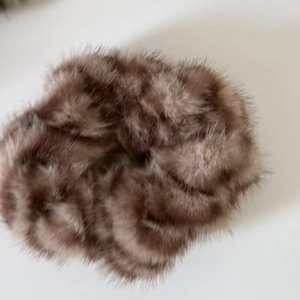 Detailed close-up of a brown fluffy faux fur hair scrunchie with soft plush texture