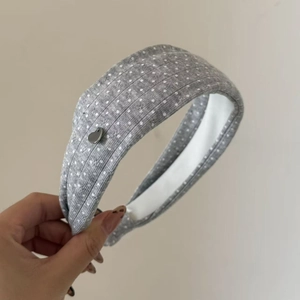 Grey knitted polka dot headband with silver heart charm and non-slip white lining