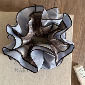 Detail of blue satin scrunchie with brown checkered double-layer design on a gift box