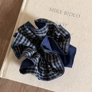 Detailed macro view of navy blue and plaid pattern fabric textures on the layered scrunchie