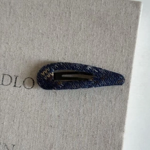 Macro detail of navy blue knitted yarn texture on water drop shaped BB hair clip