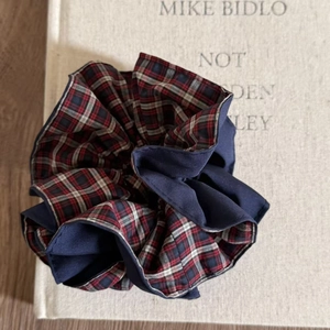 Detailed close-up of blue and plaid pattern hair scrunchie with layered fabric textures