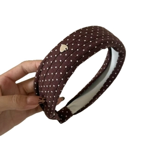 Retro brown polka dot headband with sponge padding and a heart metal charm