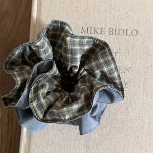 Detail of blue plaid and grey fabric scrunchie texture on a vintage book cover
