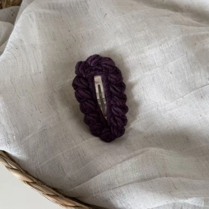 Handmade crochet plum purple hair clip with knitted texture on white background