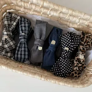 Close-up of leopard and plaid bow banana clips with gold charms in a basket