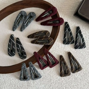 Striped wool knit BB hair clips in various shapes displayed on a wooden tray