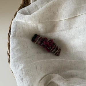 Detailed close-up of striped fabric hair clip with vintage handmade textile texture