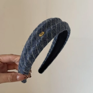 Close-up of vintage navy tweed headband with gold Hand Made metal tag and diamond patterns