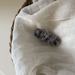 Detail of blue plush fuzzy hair clip with soft texture on a natural linen background