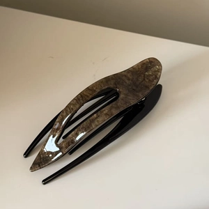 Detailed side view of large cellulose acetate duckbill hair clip with brown tortoise pattern