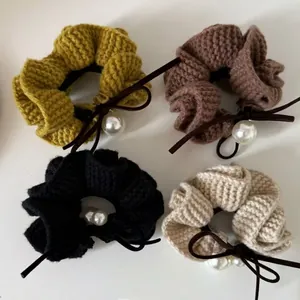 Set of four knitted hair scrunchies with pearls and bows in yellow brown black beige