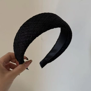 Detail shot of black tweed headband showing thick woven fabric and retro geometric texture