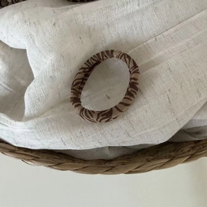 Seamless leopard and zebra pattern hair tie on rustic woven basket with soft linen texture
