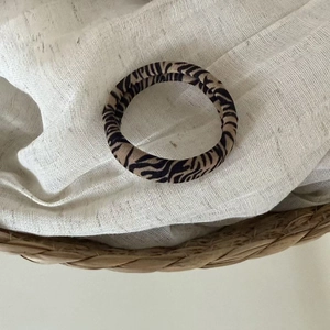 Macro detail of leopard pattern seamless hair ties in a natural woven basket