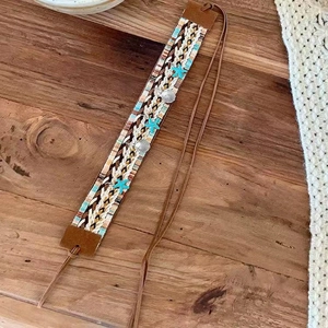 Bohemian braided hairband with star accents and seashells on natural wooden background