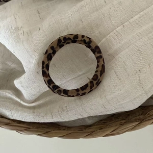 Close-up of leopard print hair scrunchies on a white fabric and rustic basket background