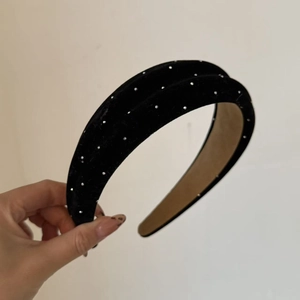 Close-up of black velvet wide headband with silver rhinestones and padded design