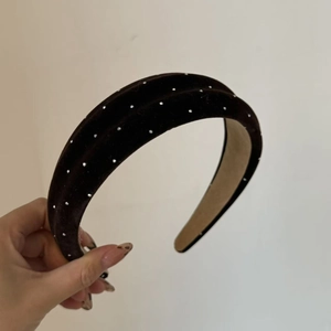Close-up of black velvet headband with sparkling rhinestones and high top design