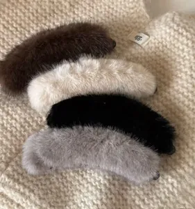 Detail of soft faux mink fur banana hair clips in four colors on knit fabric