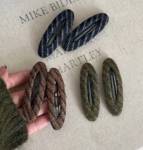 Macro detail of vintage-style striped tweed fabric texture on oval BB hair clips