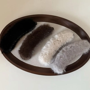 Furry mink hair banana clips in black brown beige and grey on a wooden tray