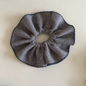 Knitted grey scrunchie with blue scalloped edges for low ponytail hairstyles