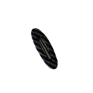Vintage knitted oval BB hair clip with dark striped texture on a white background