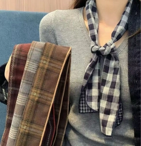 Detail view of long plaid silk scarves in black, yellow, and red vintage patterns