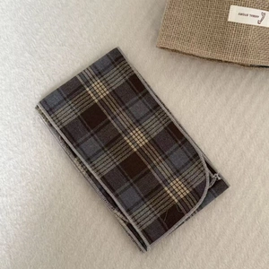 Close-up of the vintage plaid silk scarf necklace showing soft texture and fine grey stitching