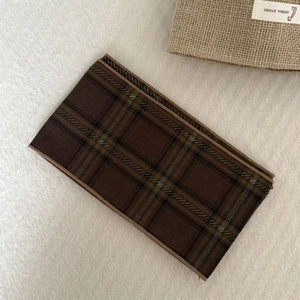 Detail of vintage brown plaid scarf necklace featuring woven fabric and British style pattern