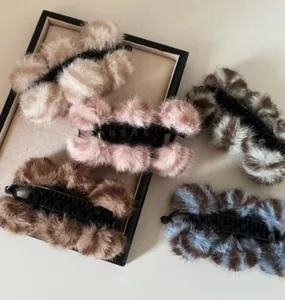Détail de cinq pinces à cheveux en peluche colorée avec une finition en fausse fourrure