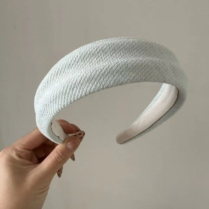 Detail showing the thick knitted texture and soft padding of the wide mint green headband