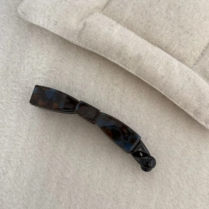 Detail showing high-gloss dark tortoiseshell pattern on curved acetate banana hair clip