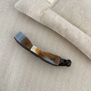 Macro shot of acetic acid banana hair clip with bow shape and mixed blue-brown textures