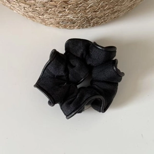 Classic black striped knitted scrunchie with leather trim on white surface