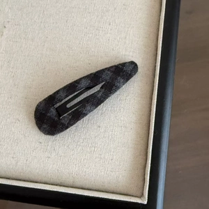 Détail de la pince à cheveux en tissu écossais vintage tons gris anthracite et noir