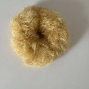 Gros plan du chouchou en peluche jaune gingembre avec une texture douce en fausse fourrure