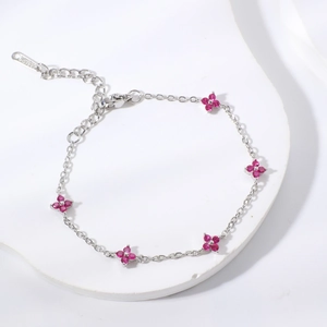 Elegant stainless steel flower bracelet with pink zircon stones on a white marble platform