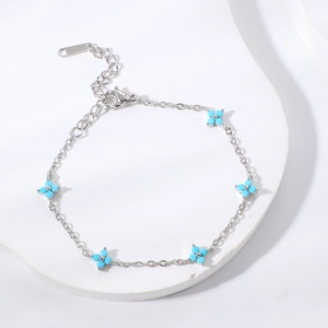 Elegant silver chain bracelet featuring five light blue flower charms on a white stone base