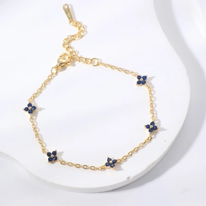 Elegant gold chain bracelet with blue flower charms and adjustable lobster clasp